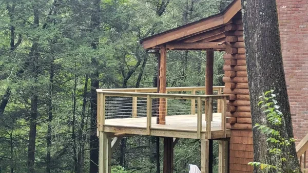Elevated deck with covered pergola on log cabin