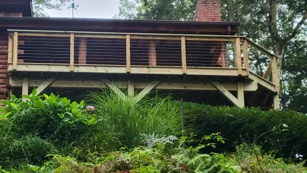 Deck with cable railing and lush garden landscaping