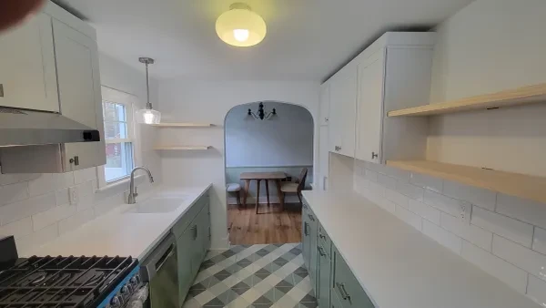 Kitchen with sage green cabinets and geometric tile floor